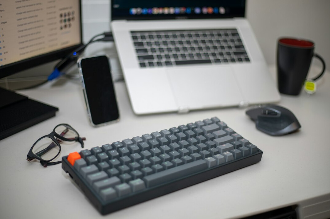 Developer typing code on a laptop in a modern office