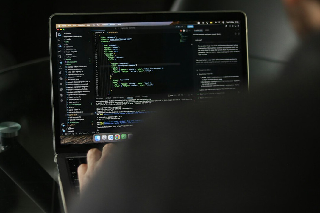 developer writing code on laptop